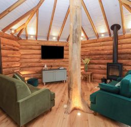 A living room with a log wall and sofas at Copper Suite in Chulmleigh