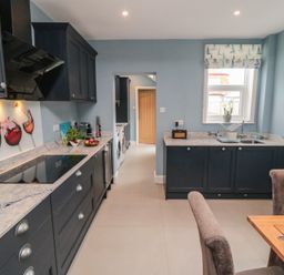 A kitchen with cabinets, sink, and dining table at 5 Station Avenue