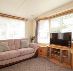 A living room with a sofa and television at Beech Lodge Wadebridge