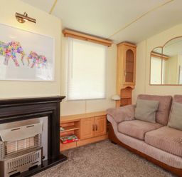 A living room with a sofa and artwork at Beech Lodge in Wadebridge