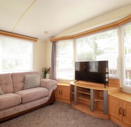 A living room with a sofa and television at Beech Lodge in Wadebridge