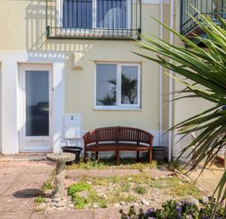 An outdoor area with a bench and fountain at 2 Lyme Mews in Seaton