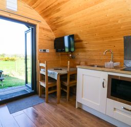 A kitchen with a table and chairs at Bron Eifion Pod 4 in Criccieth