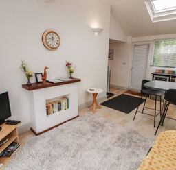 A living room with a television and a dining area at Juniper Hayloft in Ambleside