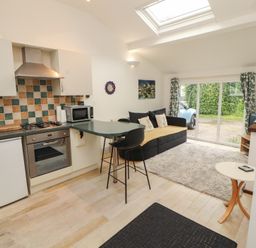 A kitchen with a gas stove and refrigerator at Juniper Hayloft in Ambleside