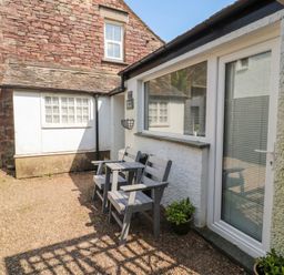 An outdoor area with chairs and a door at Juniper Hayloft Ambleside