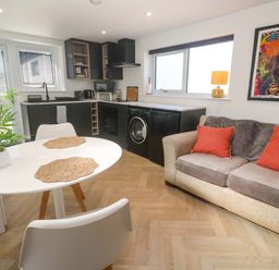 A kitchen with a dining table and sofa at The Annex in Penzance
