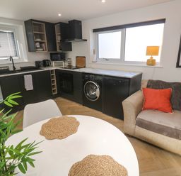 A kitchen with appliances and seating area at The Annex in Penzance