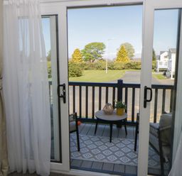 A balcony with a table and chair at Santa Maria in Llandysul