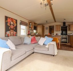 A living room with a sofa and kitchen area at CC2