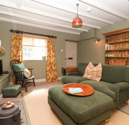 A living room with a sofa and bookshelf at The Cook’s Cottage in Malton
