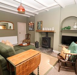 A living room with a sofa and a fireplace at The Cook’s Cottage in Malton