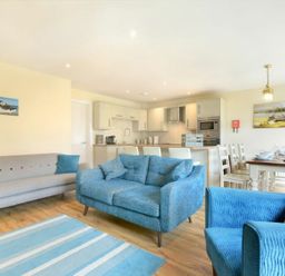 A living room with seating and dining area at Beach Walk in Chathill