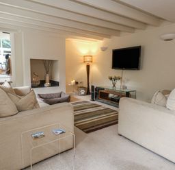 A living room with sofas and a television at Woodbine Cottage in Weymouth