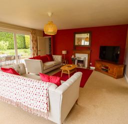 A living room with a sofa and television at Campden in Rennington near Embleton