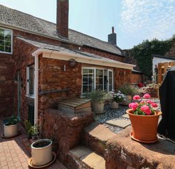 An outdoor area with flower pots and paving stones at Pete's Place in Taunton