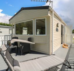 A deck area with a chair and table at Forest Retreat - FO26 in Saxmundham