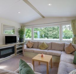 A living room with a sofa and television at Forest Retreat - FO26 in Saxmundham