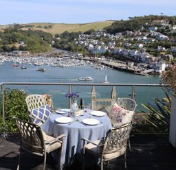 An outdoor dining area overlooking a harbor at Dart Views in Dartmouth