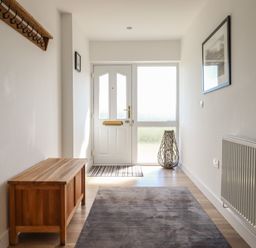 A hallway with a coat rack and bench at Tyn Y Weirglodd in Deiniolen