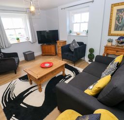 A living room with a sofa, armchairs and a coffee table at Newgale Cottage in Haverfordwest