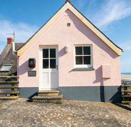 An exterior view of Newgale Cottage in Newgale with a door and window shown