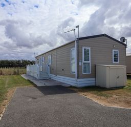 A caravan with steps and a satellite dish at Caravan i35 Towyn