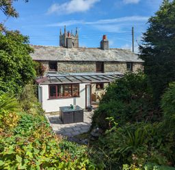 A cottage with a conservatory and patio area at Trehaverock Cottage St. Endellion near Port Isaac