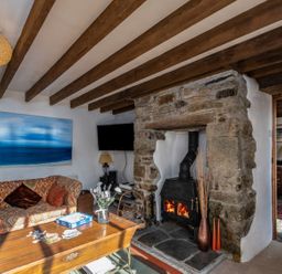 A living room with a fireplace and sofa at Trehaverock Cottage in St. Endellion near Port Isaac