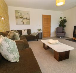 A living room with a sofa, coffee table, and fireplace at Agan Paradhis in Quintrell Downs