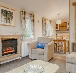 A living room with a sofa and dining table at Bingos Cabin in Holt
