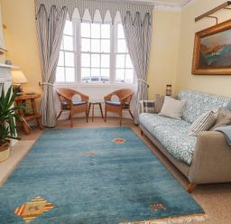 A living room with a couch and rug at No 3 By The Sea in Weymouth