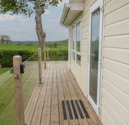 An outdoor decking area with a door at Plot 34 Carlisle