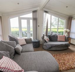 A living room with sofas and a door to the outside at Plot 34 near Armathwaite