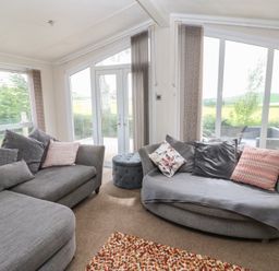 A living room with sofas and large windows at Plot 34 near Armathwaite