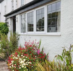 An outdoor area with flowers near a window at The Headmasters Quarters in Chudleigh
