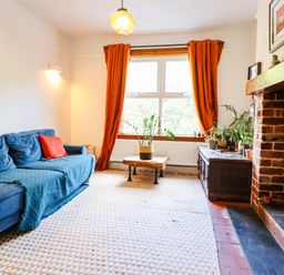A living room with a sofa, table, and plants at Hafanedd in Betws-y-Coed