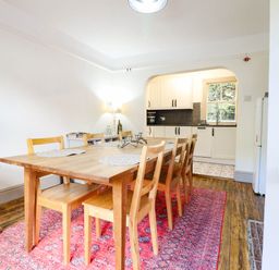 A dining room with a table and chairs and a kitchen area at Hafanedd in Betws-y-Coed