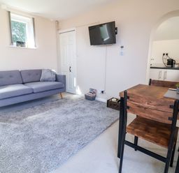 A living room with a sofa and dining table at Coach House in Highampton near Black Torrington