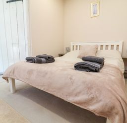A bedroom with a bed and towels at Coach House Highampton near Black Torrington