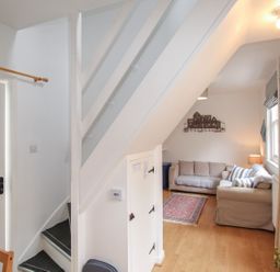 A living room with stairs and a couch at Pixie Cottage in Weymouth