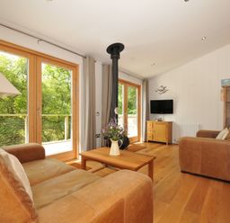 A living room with a sofa, coffee table, and television at 11 Water's Edge near Pelynt