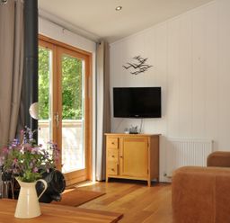 A living room with a television and wooden cabinet at 11 Water's Edge near Pelynt