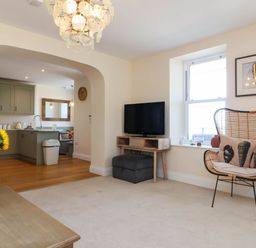 A living room with a television and chair at Sea Vista in Westward Ho!