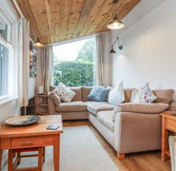 A snug with a sofa and coffee table at Dingle Dell in Braunton