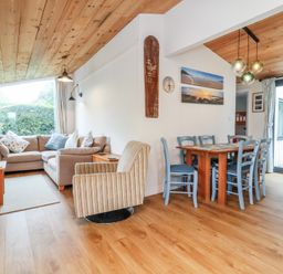 A living room with a sofa and dining area at Dingle Dell in Braunton