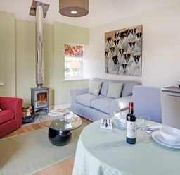 A living room with a sofa and dining table at Country Cottage Sleeps 3 with Garden and Parking