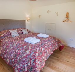 A bedroom with a large bed and bedside lamps at Country Cottage Sleeps 3 with Garden and Parking