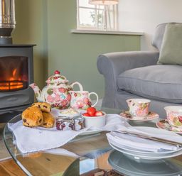 A living room with a tea set and pastries at Country Cottage Sleeps 3 with Garden and Parking