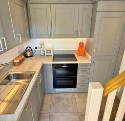 A kitchen with cabinets, sink, stove, and kettle at Charming Barn Annex with Stables New Forest Escape